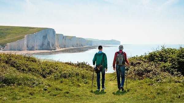 Two people walking near a cliff edge