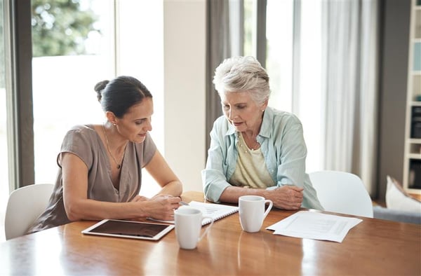 Two females peering at paperwork on a table