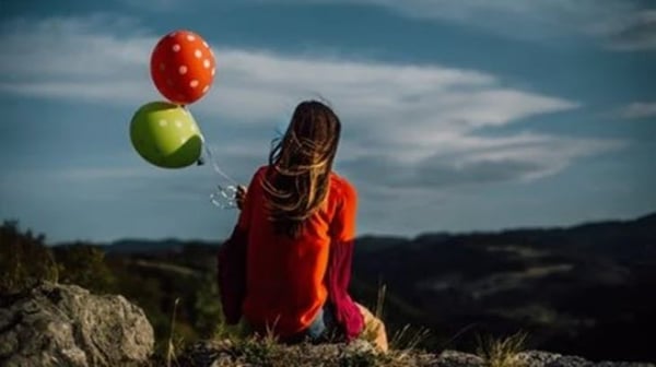 Two balloons and dark clouds
